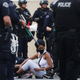 Protesters are detained by police before being arrested for a curfew violation in the Hollywood area while peacefully demonstrating over George Floyd’s death on June 1, 2020, in Los Angeles.